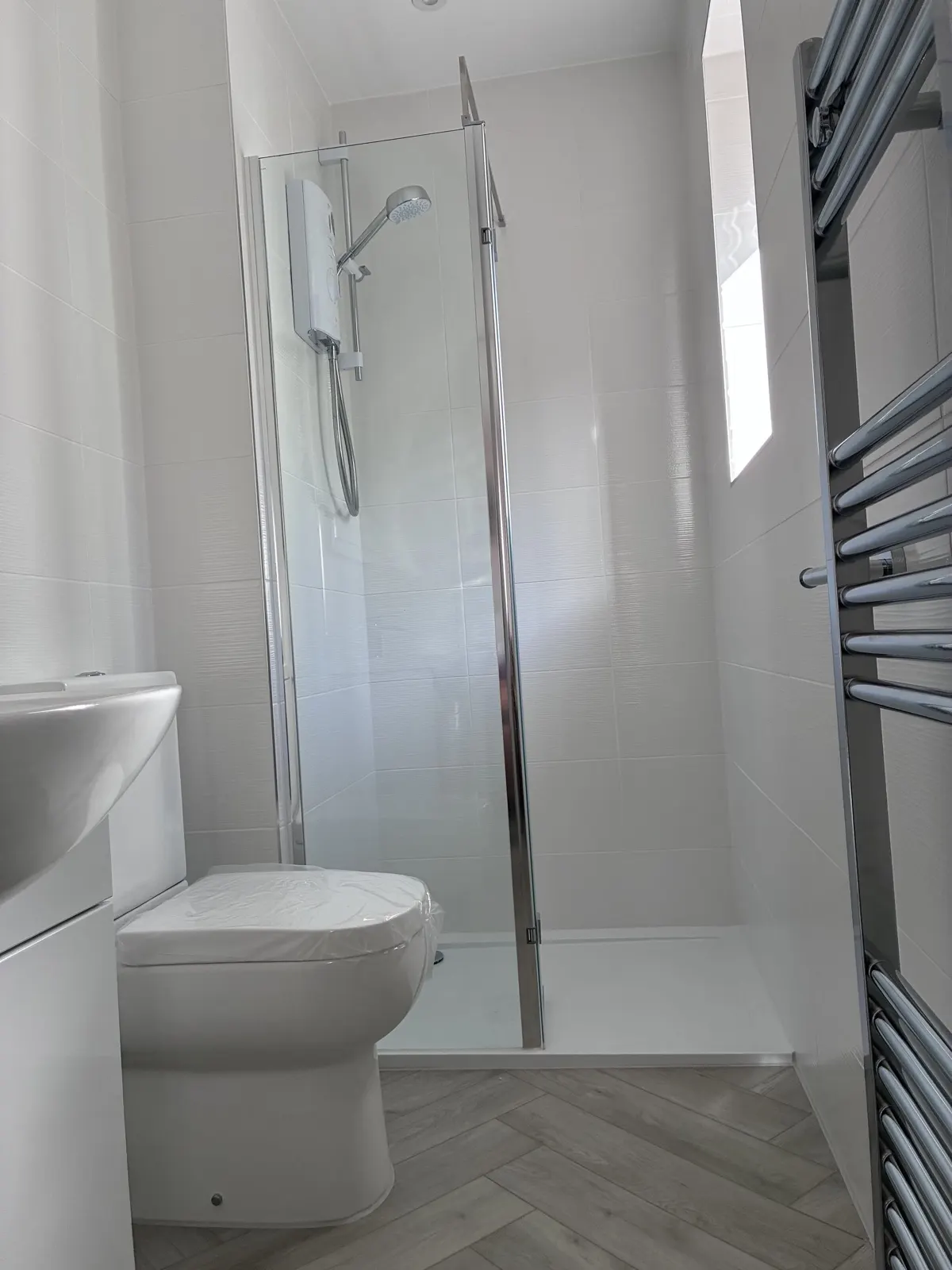 White tiled shower room with herringbone floor by Scott-Eco Builders, East Lothian